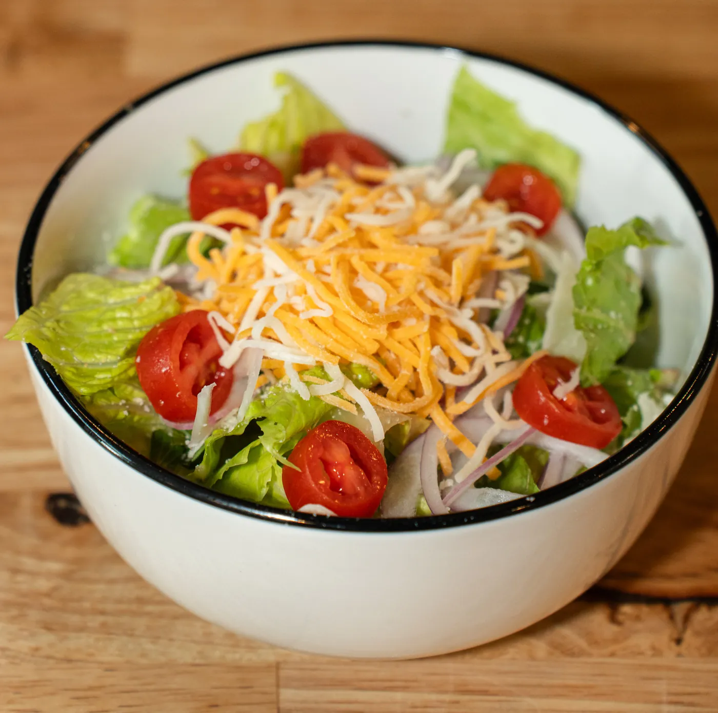 Side house salad with shredded cheese and tomatoes