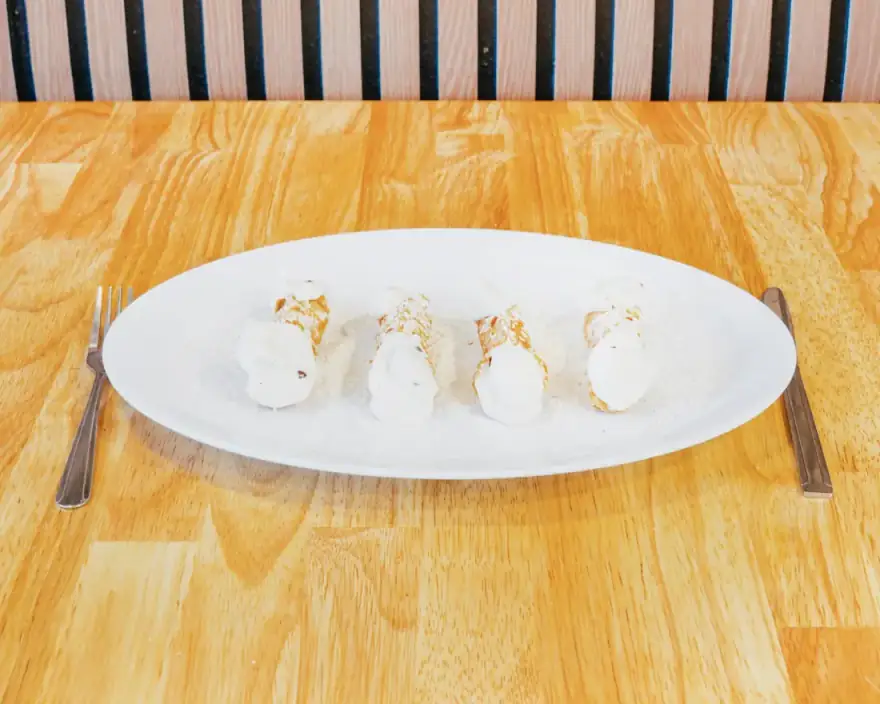 Mini cannolis dusted with powdered sugar